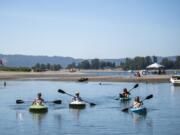 Vassar Byrd, from left, her partner John Cook, and friends Kelly Kopp and Bev Kadow kayak along the Port of Vancouver Flushing Channel connecting Columbia River and Vancouver Lake.