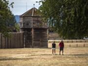 Tami Nesburg, left, and her co-worker Randy Krenelka take a walk during their lunch break Thursday at Fort Vancouver National Historic Site. Attractions such as the visitor center, reconstructed Fort Vancouver and Pearson Air Museum are closed, but the parking lots and walking paths are open.