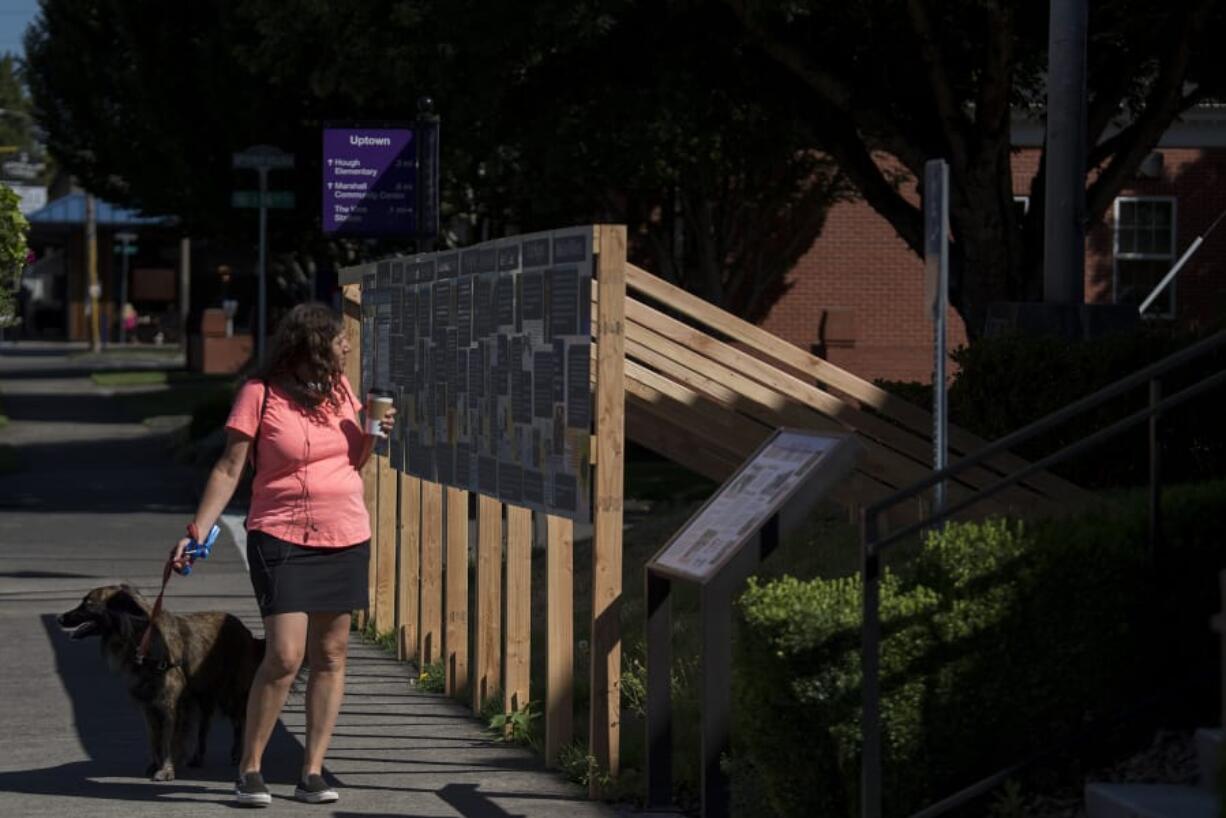 Vancouver resident Wendy Conway pauses with her dog, Roxy, 2, to check out an exhibit featuring stories from Clark County outside the Clark County Historical Museum.