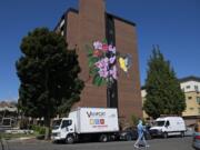 A pedestrian strolls past a new, colorful mural on the east side of Van Vista Plaza Assisted Living in downtown Vancouver on Tuesday morning. Vancouver Housing Authority commissioned the painting as part of its ongoing renovation of the 60-unit apartment building for low-income seniors at 410 W. 13th St.