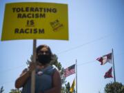 Kristen Stockwell of Vancouver stands with a crowd to protest a confederate monument and support the Black Lives Matter movement at Jefferson Davis Park near Ridgefield on August 28, 2020. Stockwell said she believed the monument behind her should be removed. ÒI think we need to stop promoting so much hate,Ó she said.