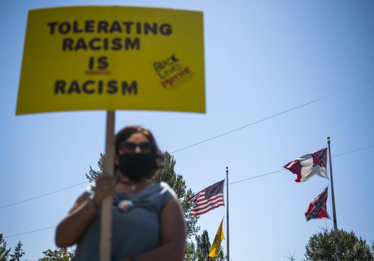 Kristen Stockwell of Vancouver stands with a crowd to protest a confederate monument and support the Black Lives Matter movement at Jefferson Davis Park near Ridgefield on August 28, 2020. Stockwell said she believed the monument behind her should be removed. ÒI think we need to stop promoting so much hate,Ó she said.