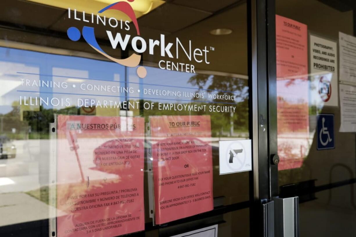 FILE - In this June 11, 2020 file photo, information signs are displayed at the closed Illinois Department of Employment Security WorkNet center in Arlington Heights, Ill. U.S. businesses sharply reduced hiring July 2020, in a sign that the resurgent viral outbreak this summer slowed the economic recovery as many states closed parts of their economies again and consumers remained cautious about spending.  (AP Photo/Nam Y.