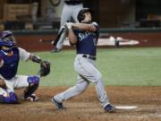 Seattle Mariners' Kyle Seager, right, follows through on a grand slam as Texas Rangers catcher Robinson Chirinos looks on in the sixth inning of a baseball game in Arlington, Texas, Monday, Aug. 10, 2020. The hit also scored Kyle Lewis, Dylan Moore and J.P. Crawford.