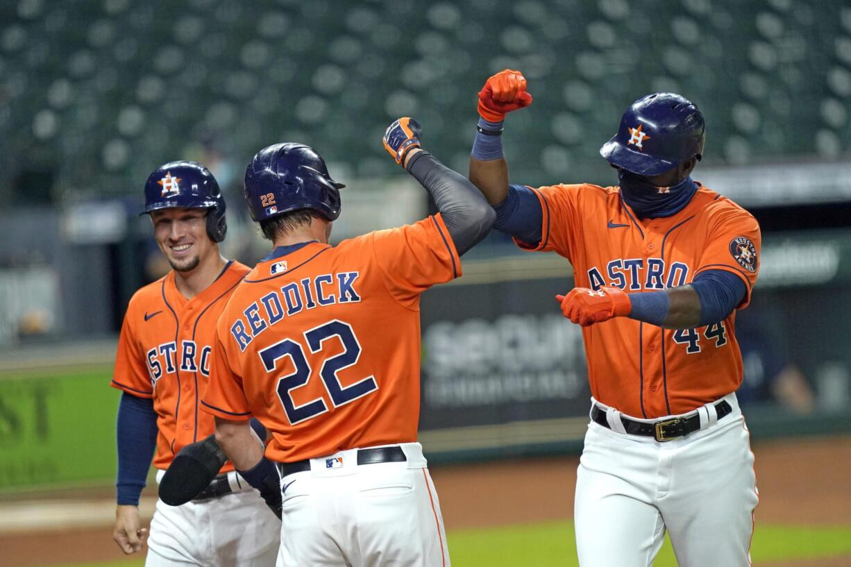 Houston Astros' Yordan Alvarez (44) celebrates with Josh Reddick (22) and Alex Bregman after they scored on Alvarez's three-run home run against the Seattle Mariners during the first inning of a baseball game Friday, Aug. 14, 2020, in Houston. (AP Photo/David J.