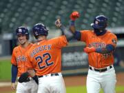 Houston Astros' Yordan Alvarez (44) celebrates with Josh Reddick (22) and Alex Bregman after they scored on Alvarez's three-run home run against the Seattle Mariners during the first inning of a baseball game Friday, Aug. 14, 2020, in Houston. (AP Photo/David J.