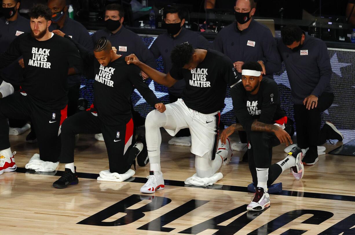 Portland Trail Blazers' Carmelo Anthony, front right, takes a knee with teammates before Game 4 of an NBA basketball first-round playoff series against the Los Angeles Lakers, Monday, Aug. 24, 2020, in Lake Buena Vista, Fla. (Kevin C.