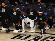 Portland Trail Blazers' Carmelo Anthony, front right, takes a knee with teammates before Game 4 of an NBA basketball first-round playoff series against the Los Angeles Lakers, Monday, Aug. 24, 2020, in Lake Buena Vista, Fla. (Kevin C.