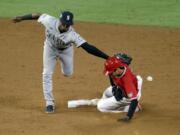 Seattle Mariners second baseman Shed Long Jr., left, misses the ball as Los Angeles Angels' Shohei Ohtani steals second base during the sixth inning of a baseball game in Anaheim, Calif., Friday, Aug. 28, 2020.