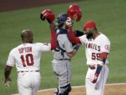 Los Angeles Angels' Jo Adell, right, celebrates his two-run home run with Justin Upton at the plate, next to Seattle Mariners catcher Austin Nola dduring the third inning of a baseball game in Anaheim, Calif., Saturday, Aug. 29, 2020.