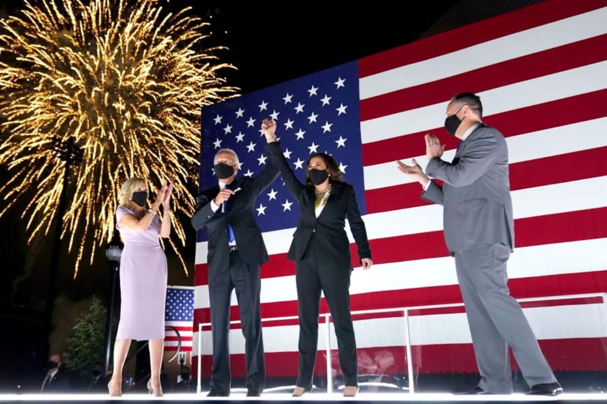 Democratic presidential candidate former Vice President Joe Biden, with Democratic vice presidential candidate Sen. Kamala Harris, D-Calif., raise their arms up as fireworks go off in the background during the fourth day of the Democratic National Convention, Thursday, Aug. 20, 2020, at the Chase Center in Wilmington, Del. Looking on are Jill Biden, far left, and Harris&#039; husband Doug Emhoff, far right.