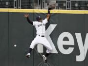 Seattle Mariners right fielder Mallex Smith hits the wall as he misses a deep fly ball from Colorado Rockies' Charlie Blackmon for a three-run double during the fifth inning of a baseball game Saturday, Aug. 8, 2020, in Seattle.