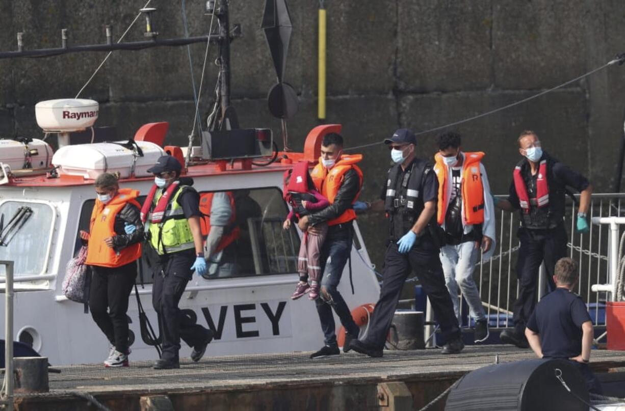 A group of people thought to be migrants are escorted by Border Force officers following a number of small boat incidents in the Channel, Thursday, Aug. 13, 2020 in Dover, England.