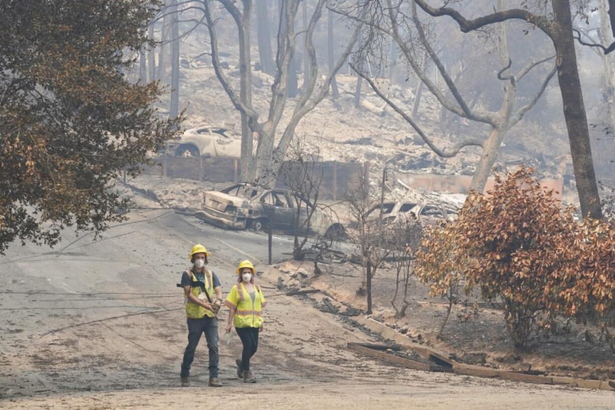 Workers with Davey Resource Group asess the damage to the trees in a neighborhood Tuesday, Aug. 25, 2020, in Boulder Creek, Calif.,after the the CZU August Lightning Complex Fire passed by.