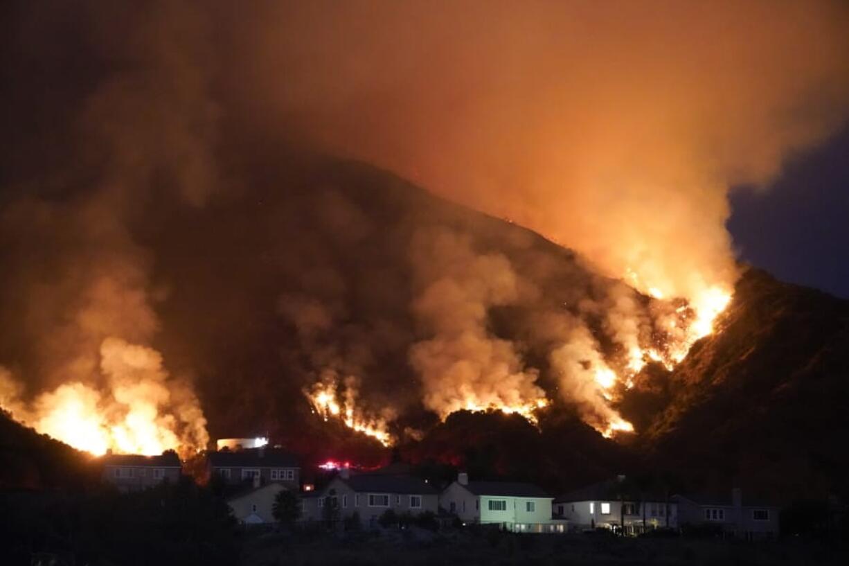 The Ranch Fire burns over a residential area, Thursday, Aug. 13, 2020, in Azusa, Calif. Heat wave conditions were making difficult work for fire crews battling brush fires and wildfires across Southern California.