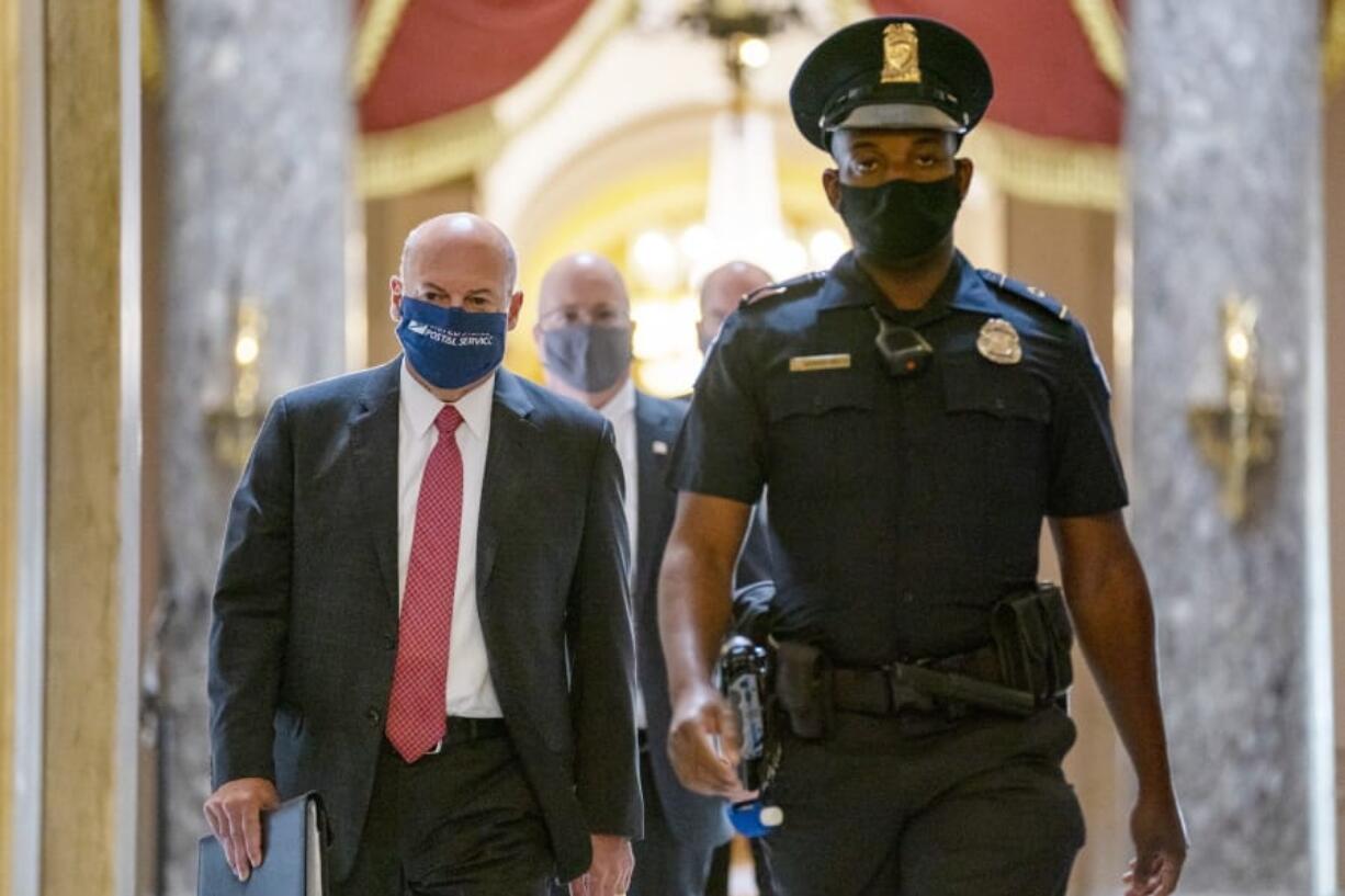 FILE - In this Aug. 5, 2020, file photo Postmaster General Louis DeJoy, left, is escorted to House Speaker Nancy Pelosi&#039;s office on Capitol Hill in Washington. The U.S. Postal Service has sent letters to 46 states and the District of Columbia, warning it cannot guarantee all ballots cast by mail for the November election will arrive in time to be counted, The Washington Post reported Friday, Aug. 14. DeJoy, a former supply-chain CEO and a major donor to President Donald Trump and other Republicans, has pushed cost-cutting measures to eliminate overtime pay and hold mail until the next day if postal distribution centers are running late.