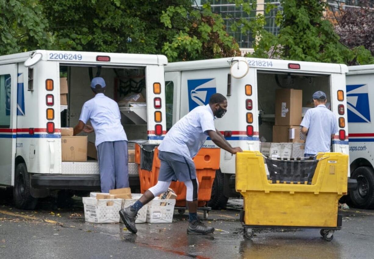 FILE - In this July 31, 2020, file photo, letter carriers load mail trucks for deliveries at a U.S. Postal Service facility in McLean, Va. The success of the 2020 presidential election could come down to a most unlikely government agency: the U.S. Postal Service.  (AP Photo/J. Scott Applewhite, File) (j.