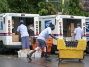 FILE - In this July 31, 2020, file photo, letter carriers load mail trucks for deliveries at a U.S. Postal Service facility in McLean, Va. The success of the 2020 presidential election could come down to a most unlikely government agency: the U.S. Postal Service.  (AP Photo/J. Scott Applewhite, File) (j.