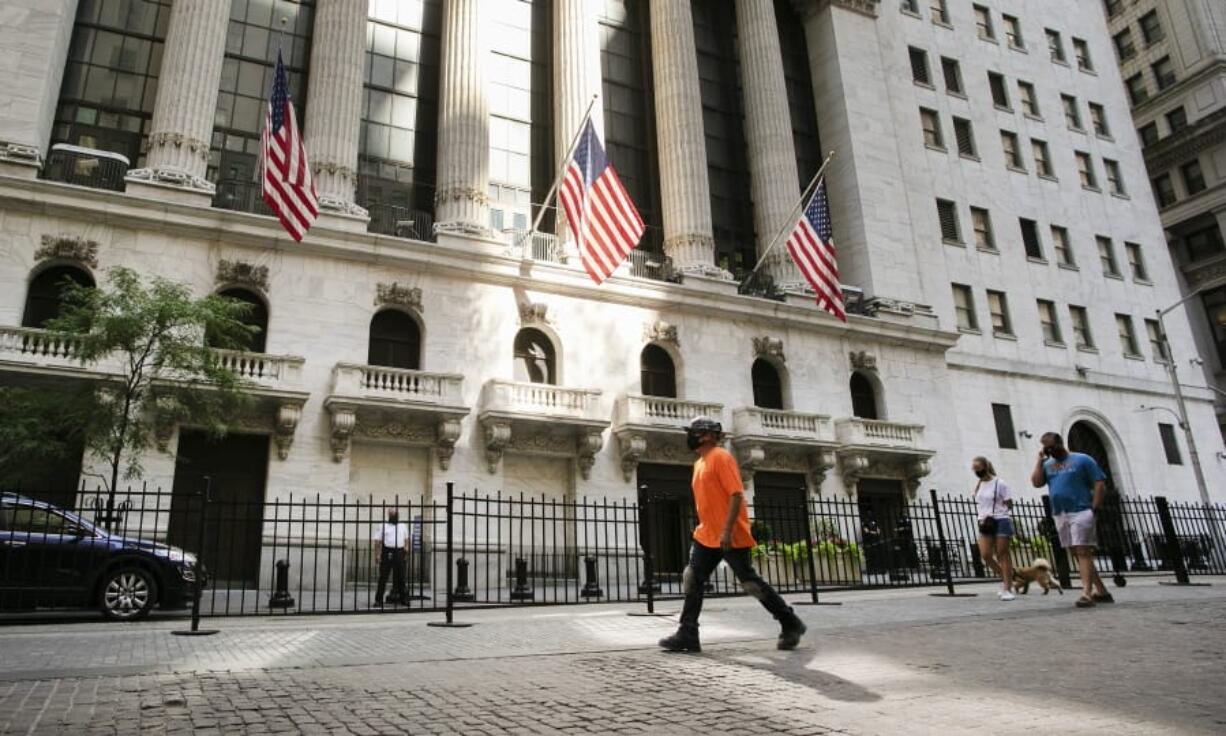 FILE- People walk by the New York Stock Exchange, Tuesday, July 21, 2020.  Stocks are rising again on Wall Street, and the S&amp;P 500 is ticking closer to its record high as it tries for a fourth straight gain. The S&amp;P 500 was 0.6% higher after the first 30 minutes of Wednesday, Aug. 5,  trading, following up on gains in European markets and across much of Asia.