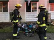 Vancouver firefighters wet down clothing that had caught fire in an apartment closet.