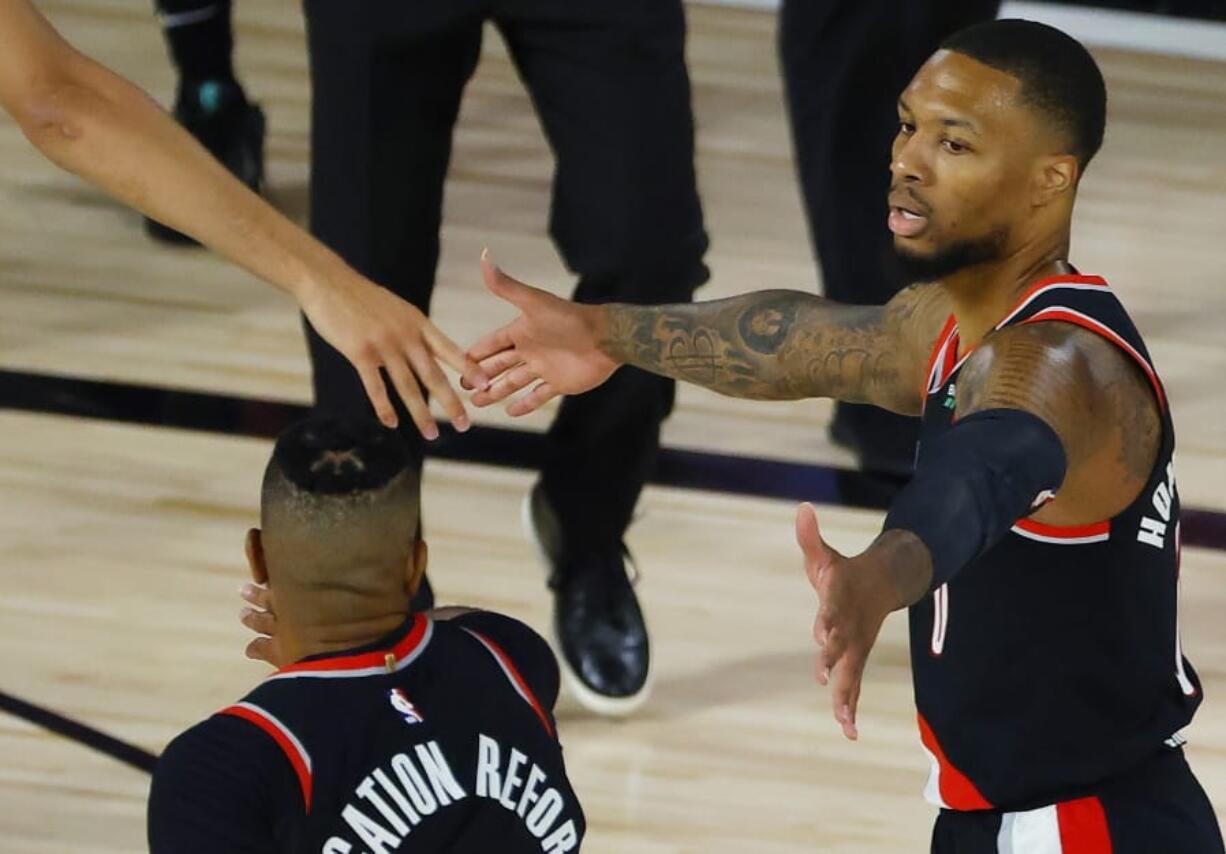 Portland Trail Blazers&#039;: Damian Lillard, right,celebrates against the Memphis Grizzlies during the first half of an NBA basketball game Saturday, Aug. 15, 2020, in Lake Buena Vista, Fla. (Kevin C.