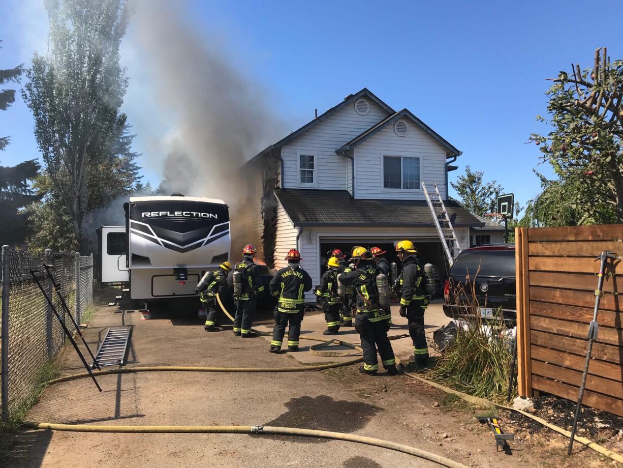 Vancouver Fire Department firefighters battle a fire in east Vancouver that started after a car crashed into a house.