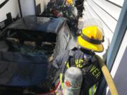 Vancouver Fire Department firefighters battle a fire in east Vancouver that started after a car crashed into a house.