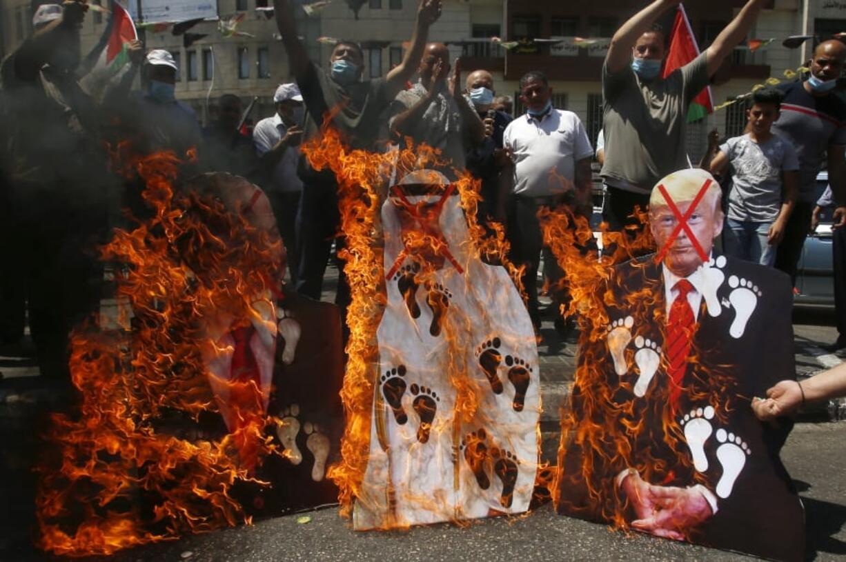 Palestinians burn pictures of U.S. President Donald Trump, Abu Dhabi Crown Prince Mohammed bin Zayed al-Nahyan and and Israeli Prime Minister Benjamin Netanyahu during a protest against the United Arab Emirates&#039; deal with Israel, in the West Bank city of Nablus, Friday, Aug.