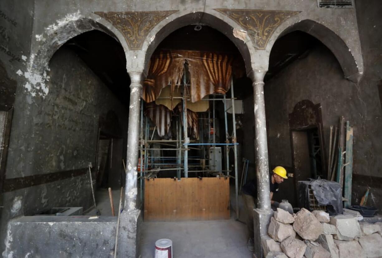 A worker works inside a heritage house that was damaged by Aug. 4 explosion that hit the seaport of Beirut, as part of it hold by scaffolding, in Beirut, Lebanon, Tuesday Aug. 25, 2020. In the streets of Beirut historic neighborhoods, workers are erecting scaffolding to support buildings that have stood for more than a century - now at risk of collapse after the massive Aug. 4 explosion that tore through the capital.