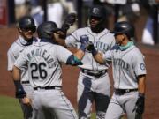 Seattle Mariners&#039; Jose Marmolejos (26) is greeted by teammates Austin Nola, left, Kyle Lewis, second from right, and Sam Haggerty, right, after hitting a grand slam during the first inning of a baseball game against the San Diego Padres, Thursday, Aug. 27, 2020, in San Diego.