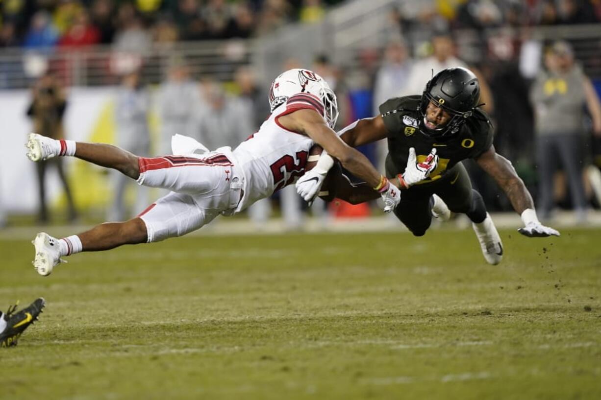 Oregon safety Jevon Holland (8) breaks up a pass for Utah wide receiver Jaylen Dixon (25) during the first half of the 2019 Pac-12 Conference championship game in Santa Clara, Calif. Holland is part of a group of Pac-12 football players who on Sunday threatened to opt out of the coming season unless its concerns about competing during the COVID-19 pandemic and other racial and economic issues in college sports are addressed.