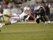 Oregon safety Jevon Holland (8) breaks up a pass for Utah wide receiver Jaylen Dixon (25) during the first half of the 2019 Pac-12 Conference championship game in Santa Clara, Calif. Holland is part of a group of Pac-12 football players who on Sunday threatened to opt out of the coming season unless its concerns about competing during the COVID-19 pandemic and other racial and economic issues in college sports are addressed.