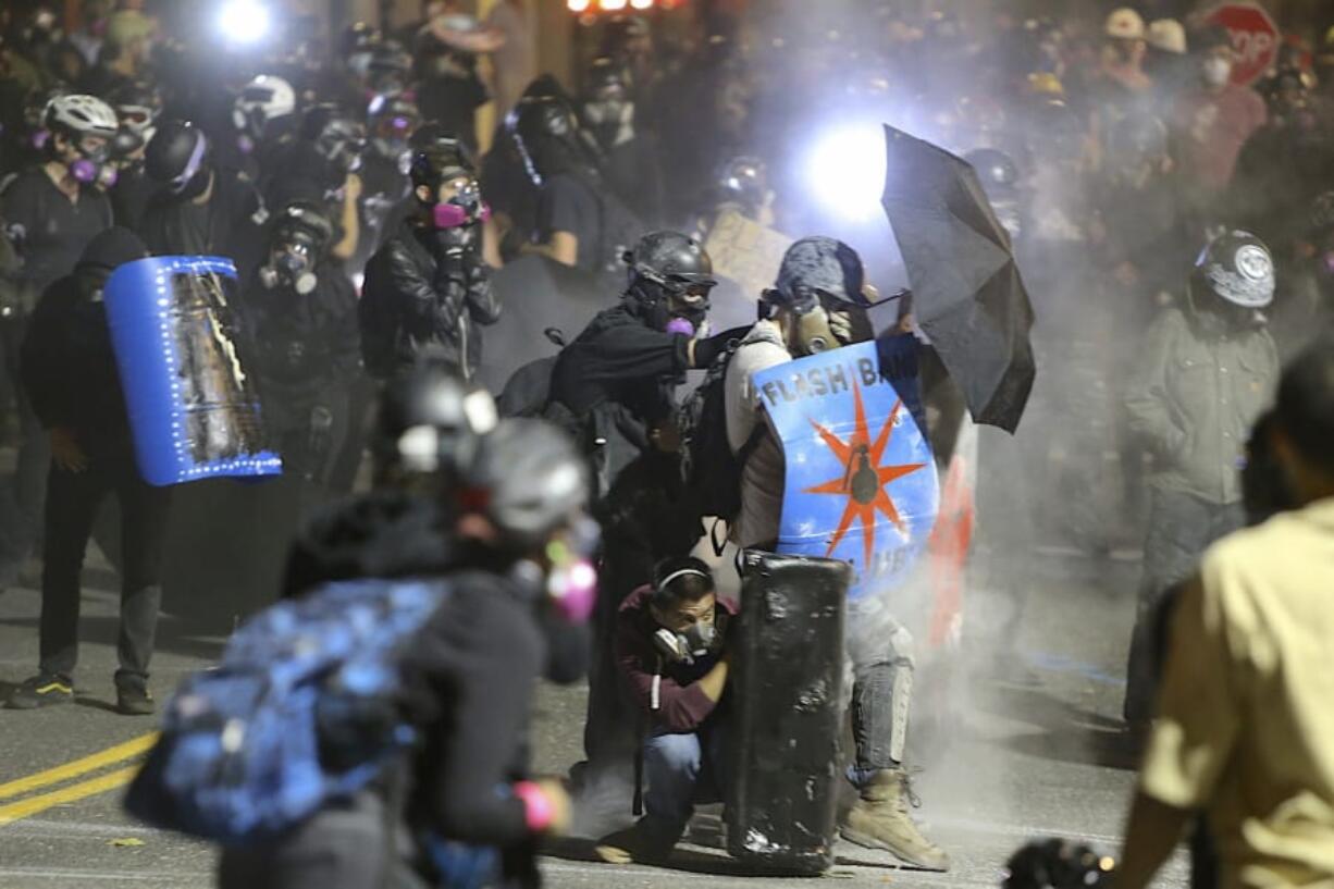 Protesters confront federal officers outside of the ICE building in Portland, Ore., Wednesday, Aug. 19, 2020.  Protesters in Portland have clashed with federal agents for the first time since July in a demonstration that targeted a U.S.