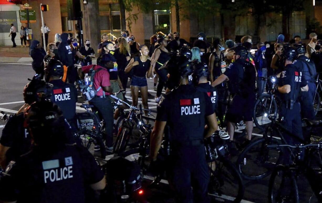 Protesters express themselves to Charlotte Mecklenburg Police bike officers at the intersection of Martin Luther King Jr. Blvd. and College Street in uptown Charlotte, N.C., on Friday, Aug. 21, 2020.