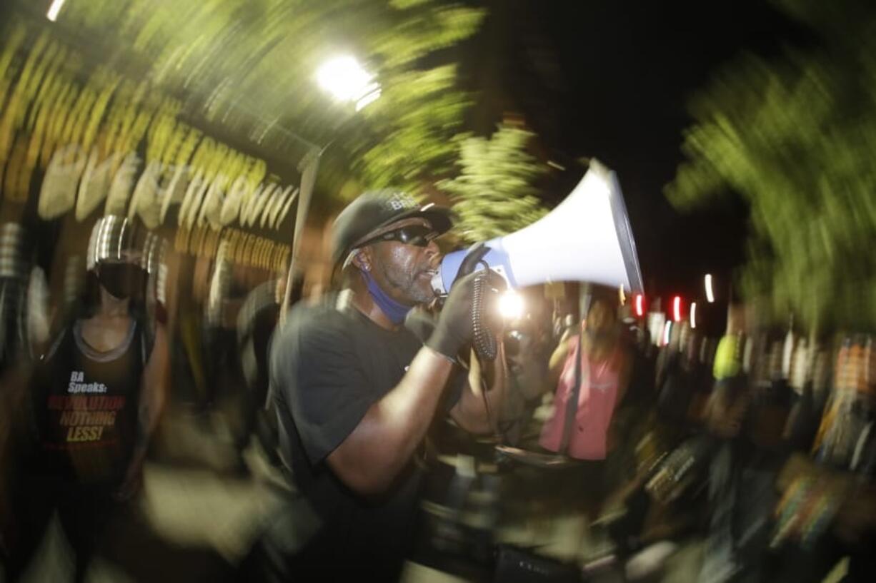 A speaker addresses the crowd during a Black Lives Matter protest at the Mark O. Hatfield United States Courthouse Thursday, July 30, 2020, in Portland, Ore. After days of clashes with federal police, the crowd outside of the federal courthouse remained peaceful Thursday night.