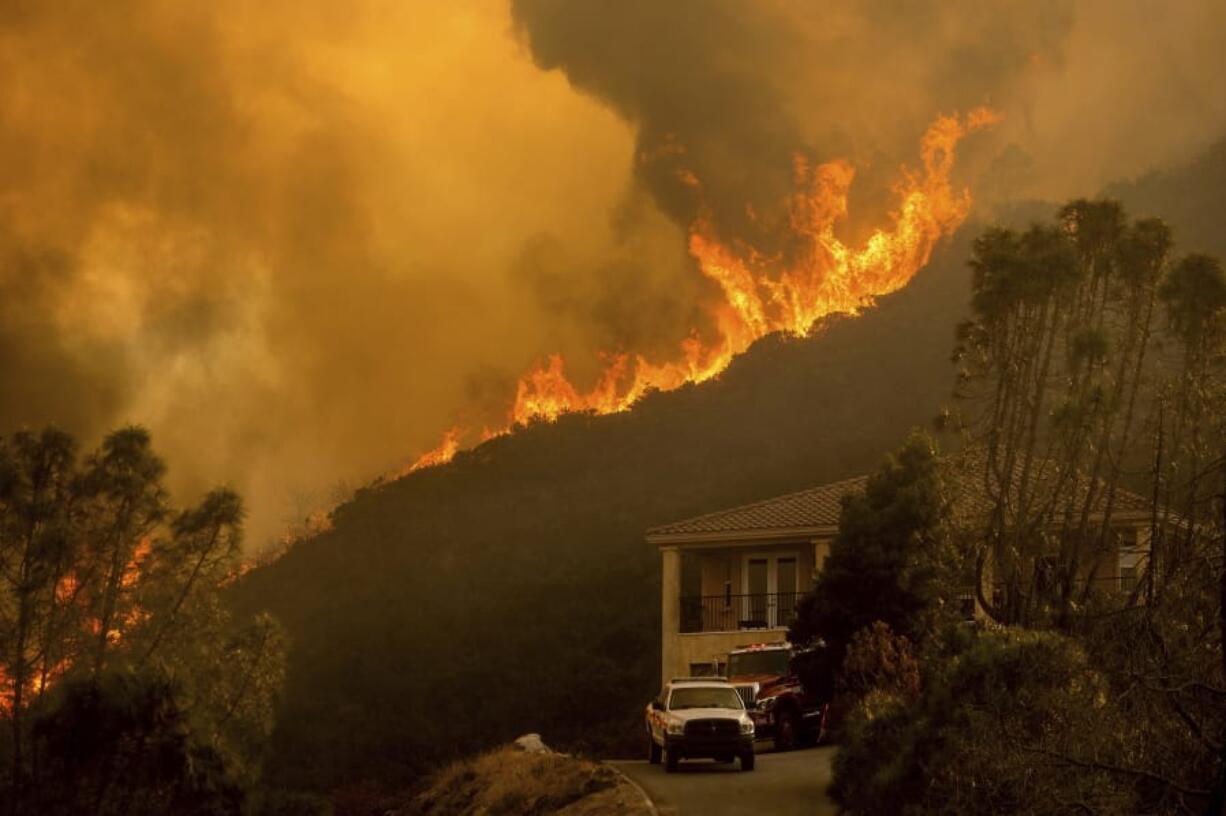 FILE - In this Monday, Aug. 17, 2020 file photo, flames from the River Fire crest a ridge in Salinas, Calif. In California, a Mediterranean climate sets up ideal conditions for fire then is worsened by climate change, says University of California, Merced, fire scientist LeRoy Westerling, who has had his home threatened twice in the last few years.