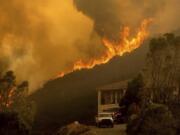 FILE - In this Monday, Aug. 17, 2020 file photo, flames from the River Fire crest a ridge in Salinas, Calif. In California, a Mediterranean climate sets up ideal conditions for fire then is worsened by climate change, says University of California, Merced, fire scientist LeRoy Westerling, who has had his home threatened twice in the last few years.