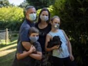 John Livingston, left, and his wife Brandy with their kids Jack, 9, left, and Amanda, 11, at their home in Camas on Aug. 14. Amanda holds one of their pet chickens, Henrietta. The family decided they will only have immediate family in the house, but the kids have had a few play dates outside with a close friend or two. &quot;It&#039;s difficult to try to figure out who&#039;s on the same page as you,&quot; Brandy said.