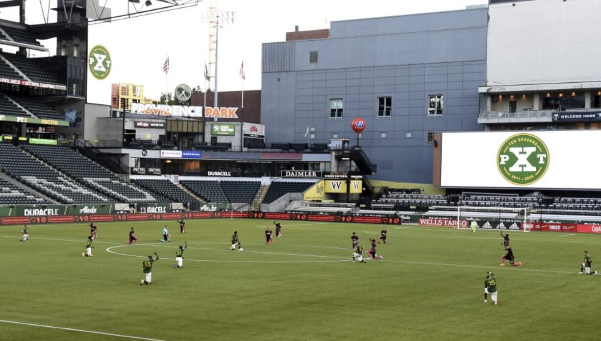 The players from both the Seattle Sounders and the Portland Timbers take a knee before an MLS soccer match in Portland, Ore., Sunday, Aug. 23, 2020.