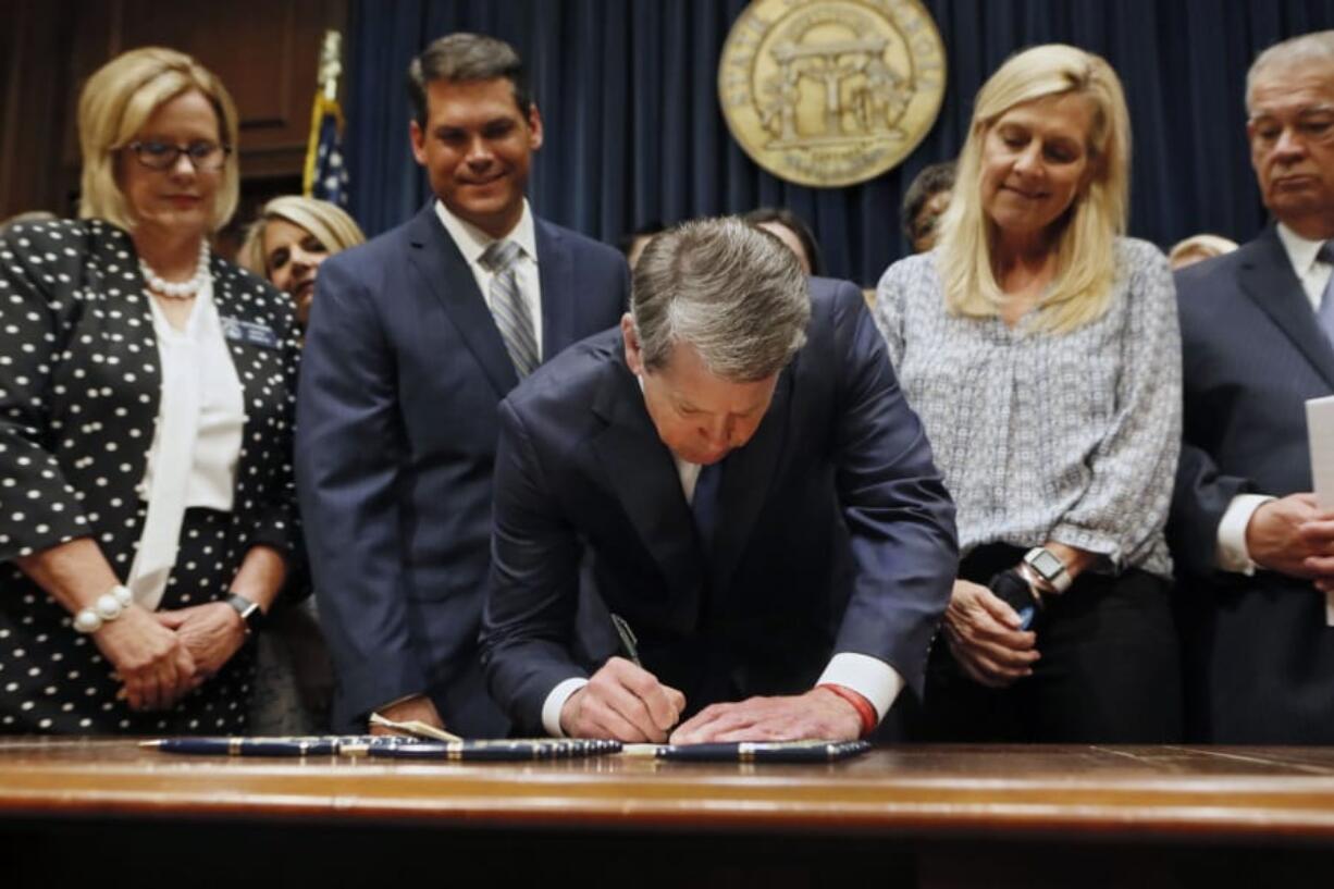 FILE - Georgia&#039;s Republican Gov. Brian Kemp, center, signs legislation Tuesday, May 7, 2019, in Atlanta, banning abortions once a fetal heartbeat can be detected, which can be as early as six weeks before many women know they&#039;re pregnant. A federal judge is permanently blocking Georgia&#039;s 2019 &quot;heartbeat&quot; abortion law, finding that it violates the U.S. Constitution. U.S. District Judge Steve Jones ruled against the state Monday, July 13, 2020, in a lawsuit filed by abortion providers and an advocacy group.