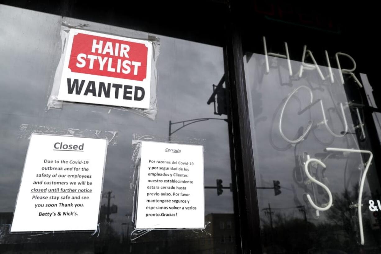 FILE - In this April 30 ,2020 file photo, a barber shop shows closed and hiring sign during the COVID-19 in Chicago.  On Thursday, Aug. 27, just over 1 million Americans applied for unemployment benefits last week, a sign that the coronavirus outbreak continues to threaten jobs even as the housing market, auto sales and other segments of the economy rebound from a springtime collapse. (AP Photo/Nam Y.