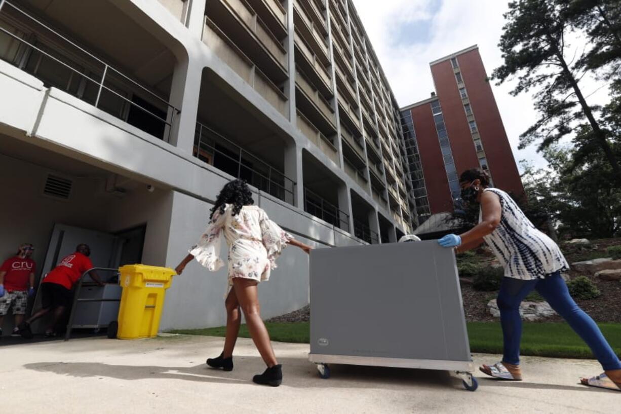 College students begin moving in for the fall semester at N.C. State University in Raleigh, N.C., Friday, July 31, 2020. The first wave of college students returning to their dorms aren&#039;t finding the typical mobs of students and parents. At N.C. State, the return of students was staggered over 10 days and students were greeted Friday by socially distant volunteers donning masks and face shields. .