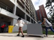 College students begin moving in for the fall semester at N.C. State University in Raleigh, N.C., Friday, July 31, 2020. The first wave of college students returning to their dorms aren&#039;t finding the typical mobs of students and parents. At N.C. State, the return of students was staggered over 10 days and students were greeted Friday by socially distant volunteers donning masks and face shields. .