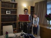 As his 3-year-old son Tzvi looks on, Rabbi Mordechai Chalk leads a service for his congregation via a teleconference app from his home in London on Friday, June 19, 2020, just before sunset. Taking services online-only has been particularly challenging for the Orthodox Jewish community, members of which are proscribed from using electronics on Shabbat, their day of rest.