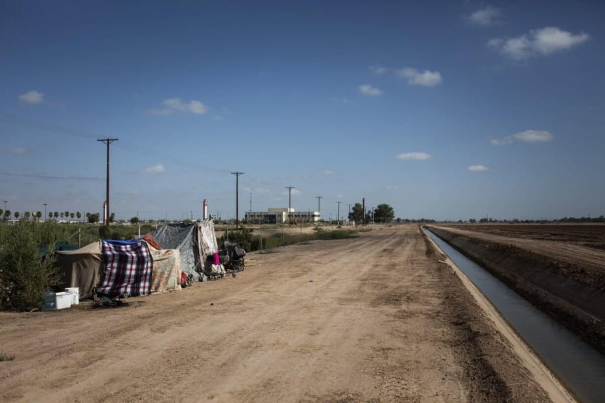 This July 24, 2020, photo shows a homeless encampment near a canal in El Centro, Calif. As support services have dwindled amid the COVID-19 pandemic, some homeless people in Imperial County have resorted to bathing in irrigation canals. Homelessness looks different in different parts of the U.S., especially in rural agricultural regions such as Imperial County.