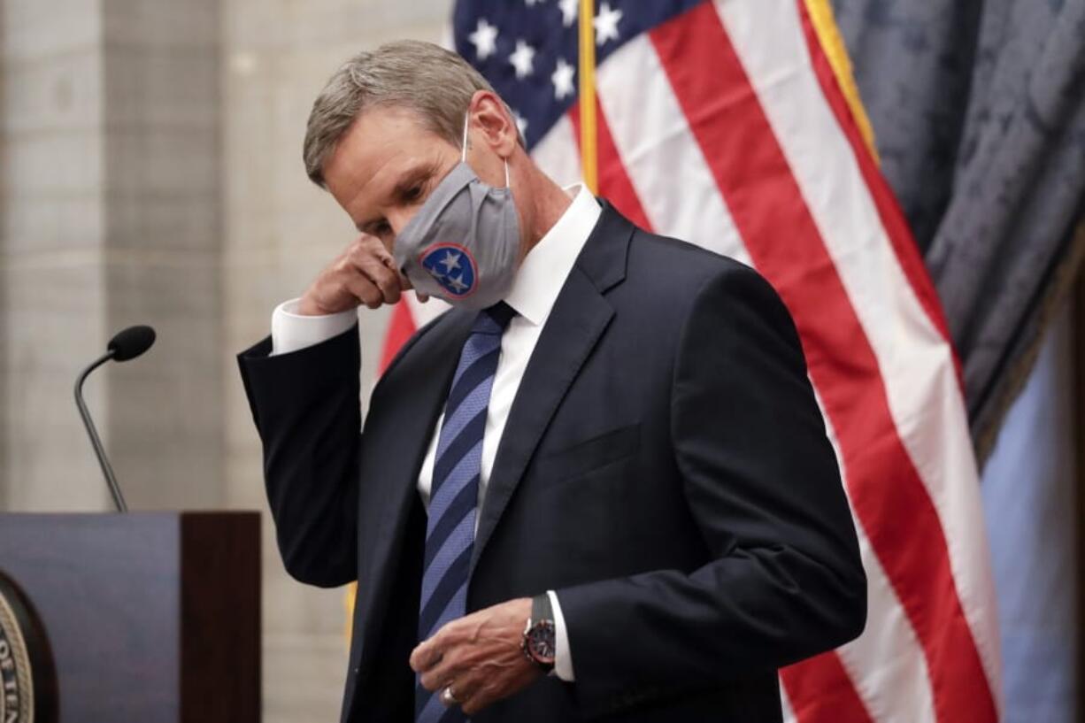 FILE - In this July 1, 2020, file photo, Tennessee Gov. Bill Lee removes his mask as he begins a news conference in Nashville, Tenn. Tennessee was one of the first states to begin reopening in late April after Lee reluctantly issued a safer-at-home order that forced businesses to close. Since then, case numbers have continued to rise in part due to more testing, but also because of an increase in community spread of the disease.