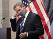 FILE - In this July 1, 2020, file photo, Tennessee Gov. Bill Lee removes his mask as he begins a news conference in Nashville, Tenn. Tennessee was one of the first states to begin reopening in late April after Lee reluctantly issued a safer-at-home order that forced businesses to close. Since then, case numbers have continued to rise in part due to more testing, but also because of an increase in community spread of the disease.