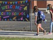 Cimmie Hunter, left, and Cadence Ludlow, both sixth graders, arrive at Liberty Elementary School for the first day of class Monday in Murray, Utah.