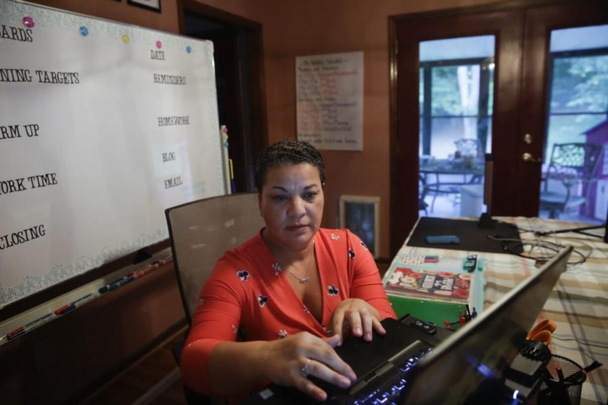 Aimee Rodriguez Webb works on her computer Tuesday at her dinning room table that she set up as a virtual classroom for a Cobb County school in Marietta, Ga. After a rocky transition to distance learning last spring, Webb is determined to do better this fall.