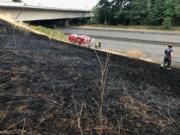 A vehicle fire on state Highway 14 spread to nearby grass Wednesday evening, burning about an acre before being brought under control by the Vancouver Fire Department.